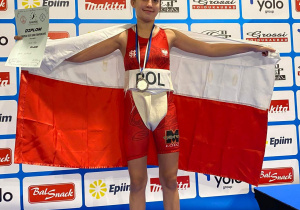 Agata na podium ze srebrnym medalem trzymająca flagę Polski