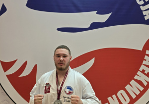 Igor na tle loga Polskiej Federacji Taekwon-do