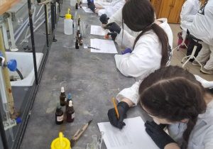 Uczniowie w laboratorium rozwiązujący zadania.