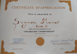 Na dyplomie: Certificate of Appreciation. This is awarded to Szymon Marat. Grade 3f. For Achievements in „Vocabulary Championship”. Advanced Level. XLII LO im. Ireny Sendlerowej w Łodzi. Pieczątka i podpis wicedyrektora. Podpisy jury.